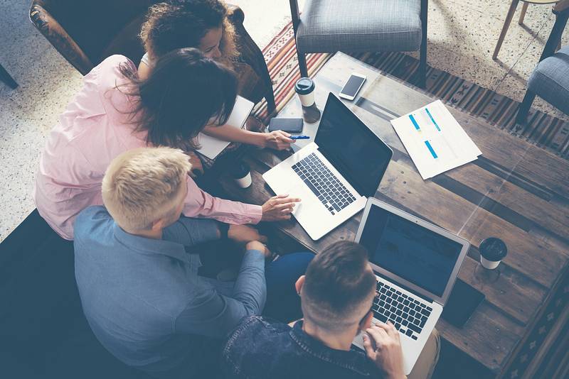 A group of diverse individuals engaged in a lively conversation while surrounded by vibrant visuals, representing the impact of Visual Storytelling in Marketing